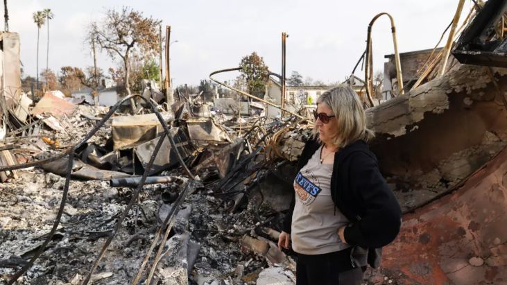 Carrie Meyers, owner of Steve’s Pets, surveys the rubble at her longtime pet store, which was destroyed in the Eaton fire. (LA Times/Carlin Stiehl)