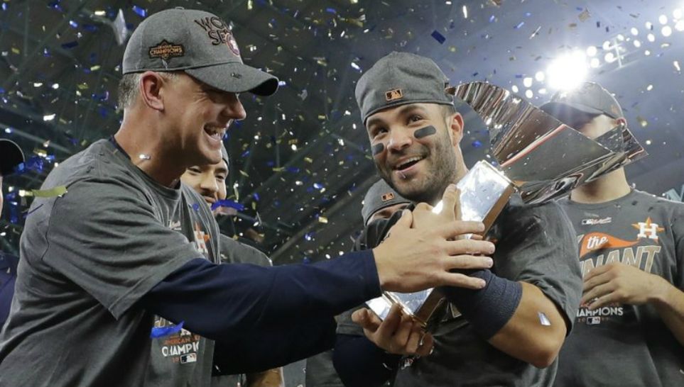 In this Oct. 21, 2017, file photo, Houston Astros manager A.J. Hinch and Jose Altuve hold the championship trophy after Game 7 of baseball's American League Championship Series against the New York Yankees, in Houston. Altuve was named The Associated Press Male Athlete of the Year on Wednesday, Dec. 27, 2017. (AP Photo/David J. Phillip, File)