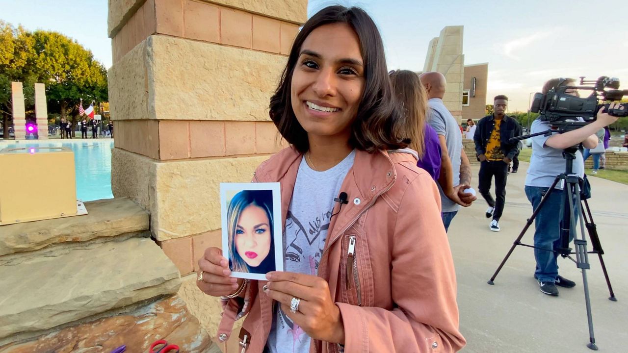 Letica Zapata Falley holds a picture of her late cousin Amanda Johnson who was murdered in April 2021. Johnson Was honored at the annual Illuminate Irving event which remembers victims and survivors of domestic violence. (Spectrum News 1/Lupe Zapata)