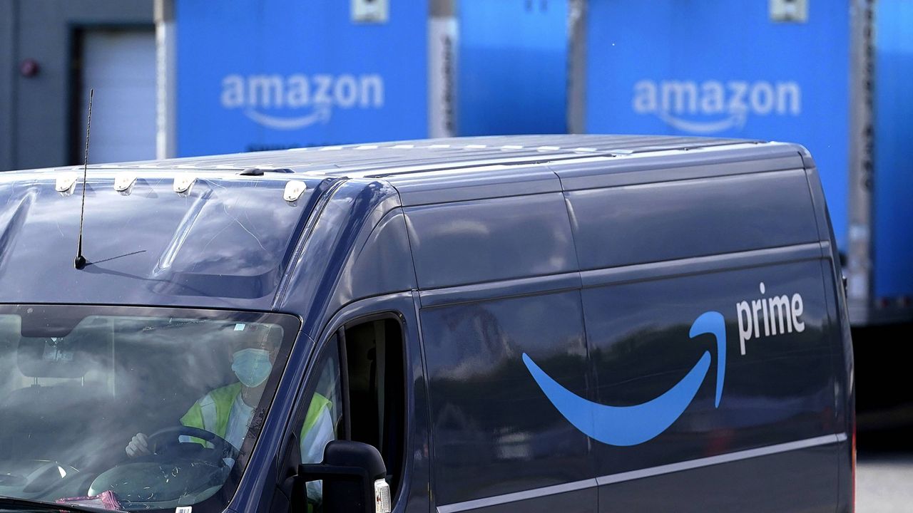 An Amazon Prime logo appears on the side of a delivery van as it departs a warehouse in Dedham, Mass. (AP Photo/Steven Senne, File)