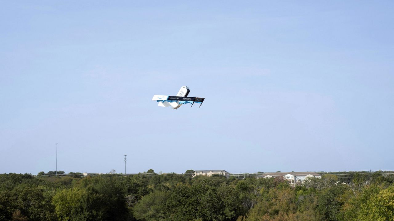 This photo provided by Amazon shows a drone delivering presciption drugs in College Station, Texas. Amazon will soon make prescription drugs fall from the sky when the e-commerce giant becomes the latest company to test drone deliveries for medications. The company said Wednesday, Oct. 18, 2023 that customers in College Station, Texas, can now get prescriptions delivered by a drone within an hour of placing their order. (Amazon via AP)