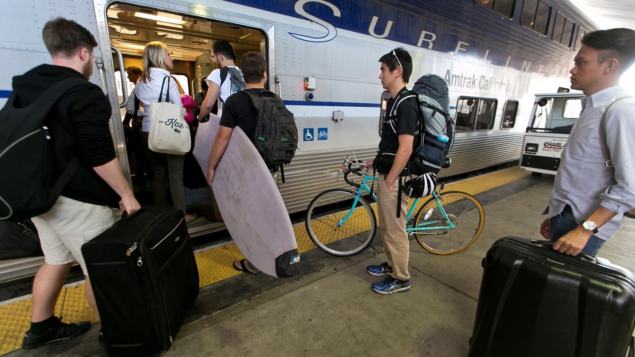 Passengers board an Amtrak Surfliner train bound to Santa Barbara, Calif., at Union Station in Los Angeles, Wednesday, Nov. 26, 2014, a day before Thanksgiving. (AP Photo/Damian Dovarganes)