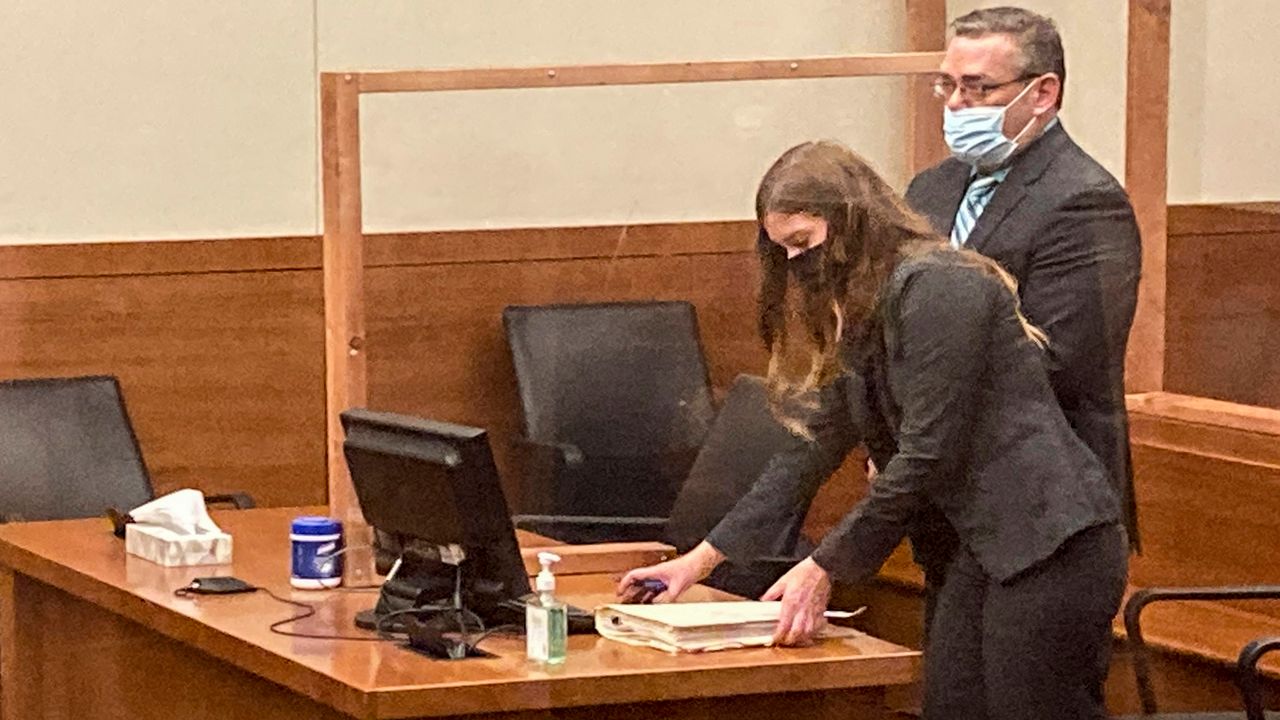 Former Ohio police officer Adam Coy stands during a Franklin County hearing as defense attorney Kaitlyn Stephens checks her notes, Oct. 4, 2021, in Columbus, Ohio. (AP Photo/Andrew Welsh-Huggins, File)