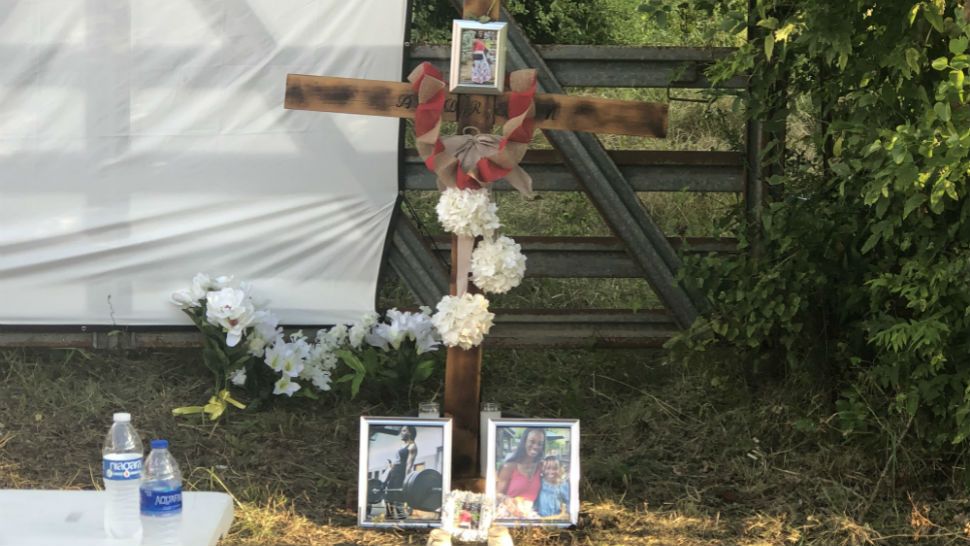 A cross bears photos honoring Andreen McDonald near the place where her body was found in July. (Chris Grisby/Spectrum News)
