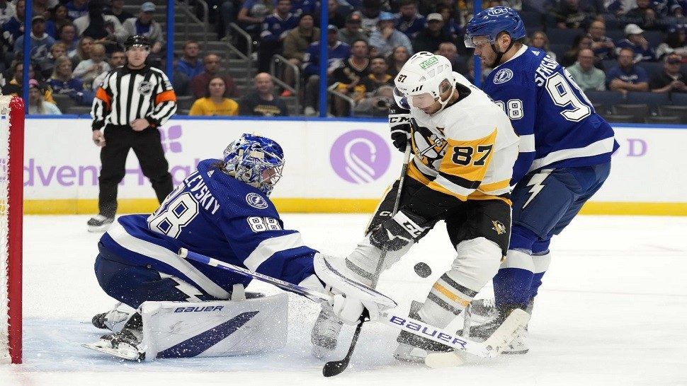 Tampa Bay Lightning goaltender Andrei Vasilevskiy (88) stops a shot by Pittsburgh Penguins center Sidney Crosby (87) during the first period of an NHL hockey game Thursday, Nov. 30, 2023, in Tampa, Fla. Defending for Tampa Bay is Mikhail Sergachev (98). (AP Photo/Chris O'Meara)