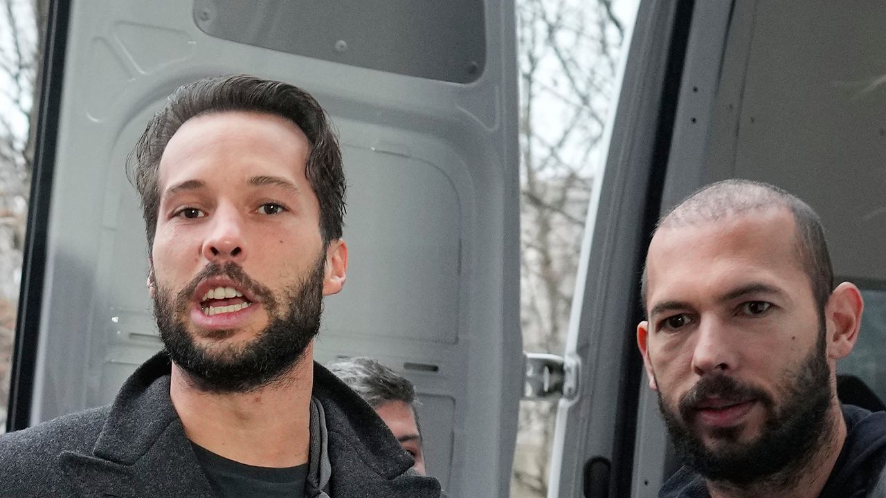 Police officers escort Andrew Tate, right, handcuffed to his brother Tristan, outside the Directorate for Investigating Organized Crime and Terrorism (DIICOT) where prosecutors examine electronic equipment confiscated during the investigation in their case, in Bucharest, Romania, Thursday, Jan. 26, 2023. (AP Photo/Vadim Ghirda)