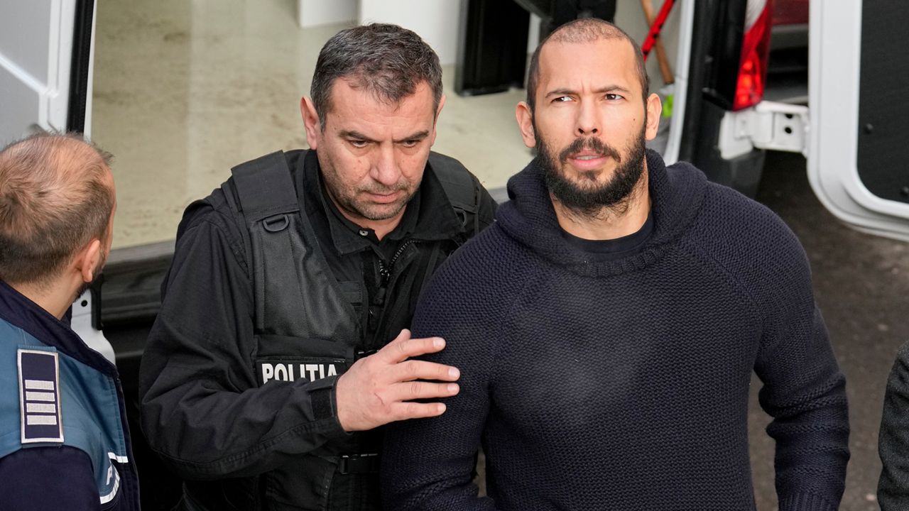 Police officers escort Andrew Tate, right, handcuffed to his brother Tristan Tate, to the Court of Appeal in Bucharest, Romania, Wednesday, Feb. 1, 2023. (AP Photo/Vadim Ghirda)