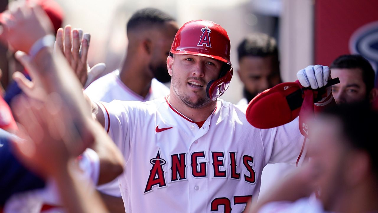 Los Angeles Angels' Mike Trout (27) celebrates in the dugout after scoring off of a single hit by Taylor Ward during the first inning of a baseball game against the Texas Rangers in Anaheim, Calif., Sunday, Oct. 2, 2022. (AP Photo/Ashley Landis)