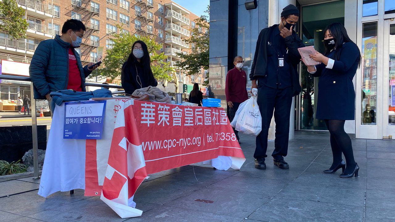 Outreach table with staff and volunteers talking to passersby.