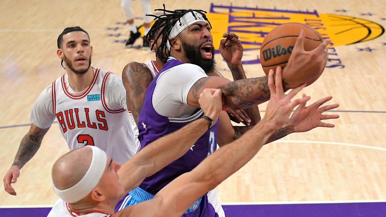 Los Angeles Lakers forward Anthony Davis, right, grabs a rebound away from Chicago Bulls guard Alex Caruso, lower left, and forward Derrick Jones Jr., second from right, as guard Lonzo Ball watches during the first half of an NBA basketball game Monday, Nov. 15, 2021, in Los Angeles. (AP Photo/Mark J. Terrill)