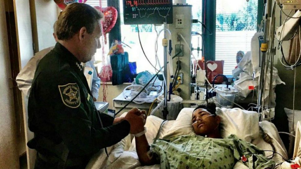 This image made available by the Broward County Sheriff’s Office on Sunday, Feb. 18, 2018, shows Sheriff Scott Israel, holding the hand of Anthony Borges, 15, a student at Marjory Stoneman Douglas High School. The teenager was shot five times during the massacre on Valentine’s Day that killed 17 students. Borges is being credited with saving the lives of at least 20 other students. (Broward County Sheriff’s Office via AP)