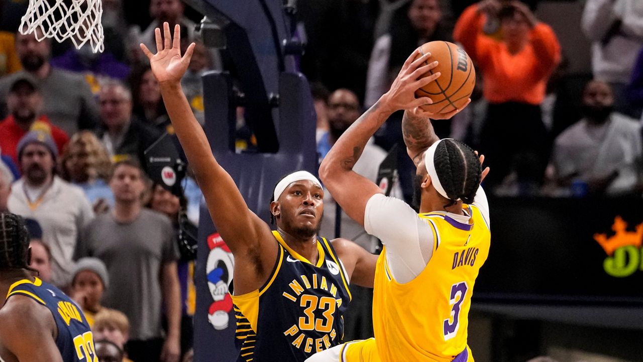 Los Angeles Lakers forward Anthony Davis (3) hits a basket over Indiana Pacers center Myles Turner (33) to take the lead in the closing seconds of the second half of an NBA basketball game in Indianapolis, Thursday, Feb. 2, 2023. (AP Photo/Michael Conroy)