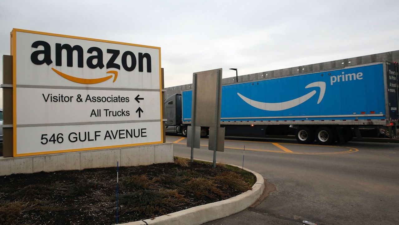 File photo of an Amazon Prime truck passes by a sign outside an Amazon fulfillment center March 19, 2020 in Staten Island, N.Y. (AP Photo/Kathy Willens, File)