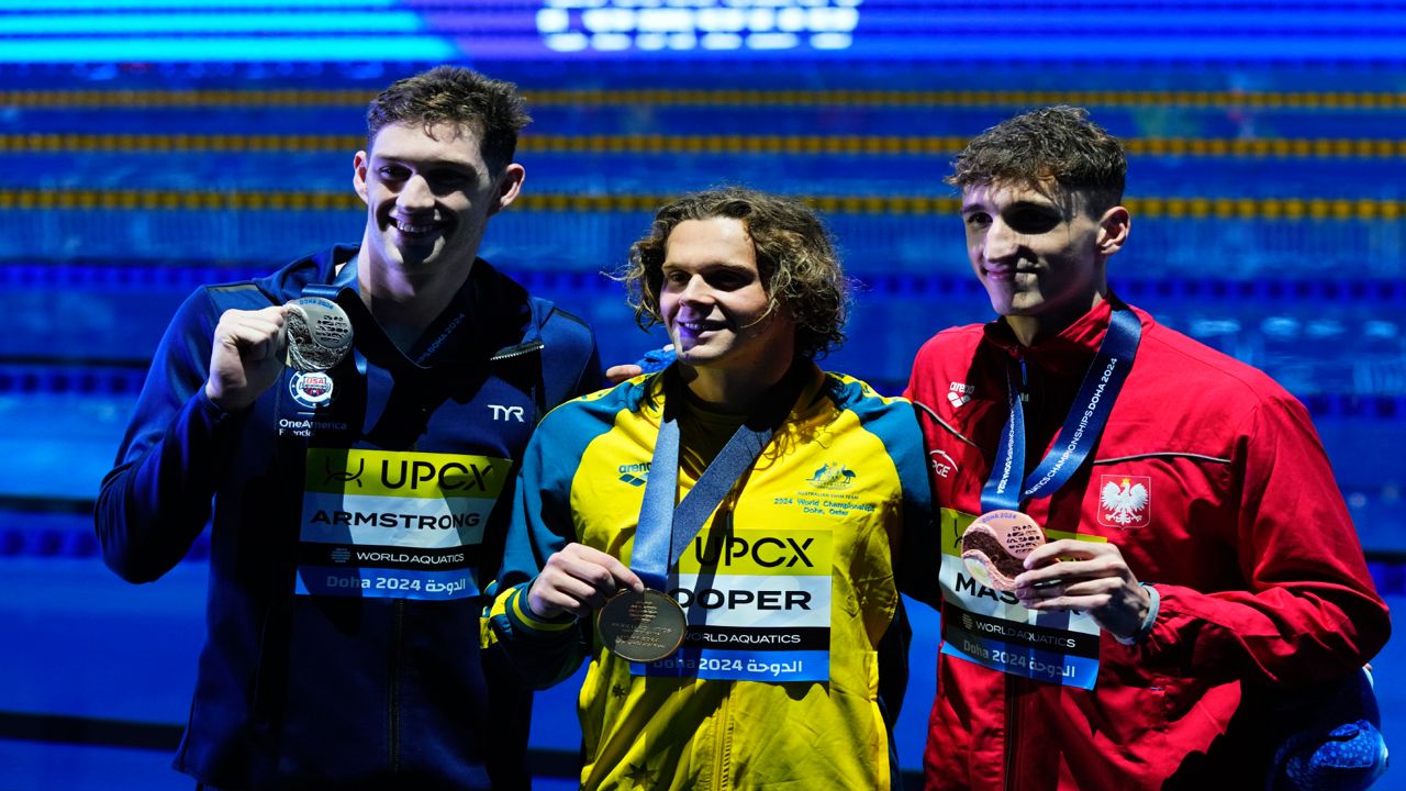 Hunter Armstrong of the United States, Isaac Cooper of Australia and Ksawery Masiuk of Poland, from left to right, pose after the Men's 50m Backstroke final at the World Aquatics Championships in Doha, Qatar, Sunday, Feb. 18, 2024.