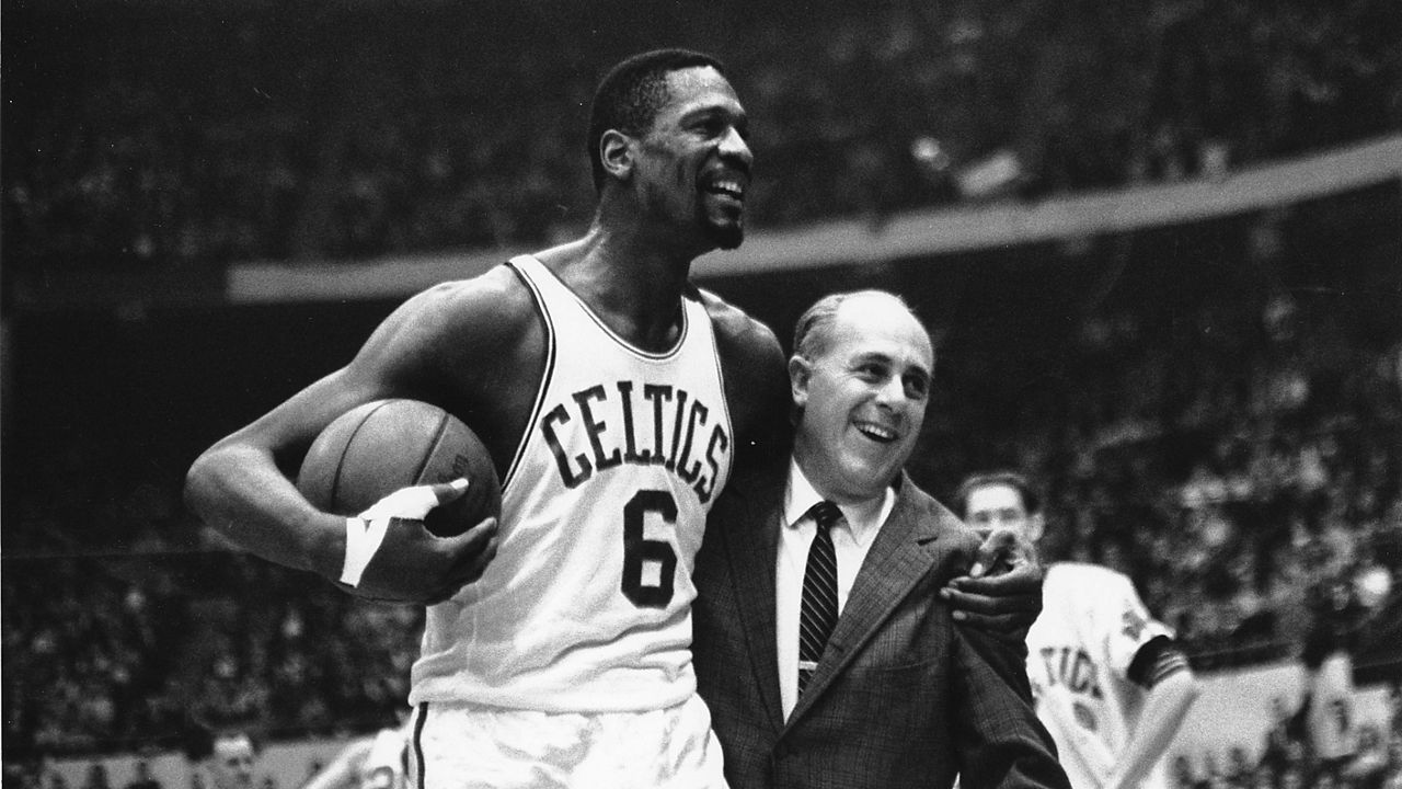 Bill Russell, left, star of the Boston Celtics is congratulated by coach Arnold "Red" Auerbach after scoring his 10,000th point on Dec. 12, 1964. (AP Photo/Bill Chaplis, file)