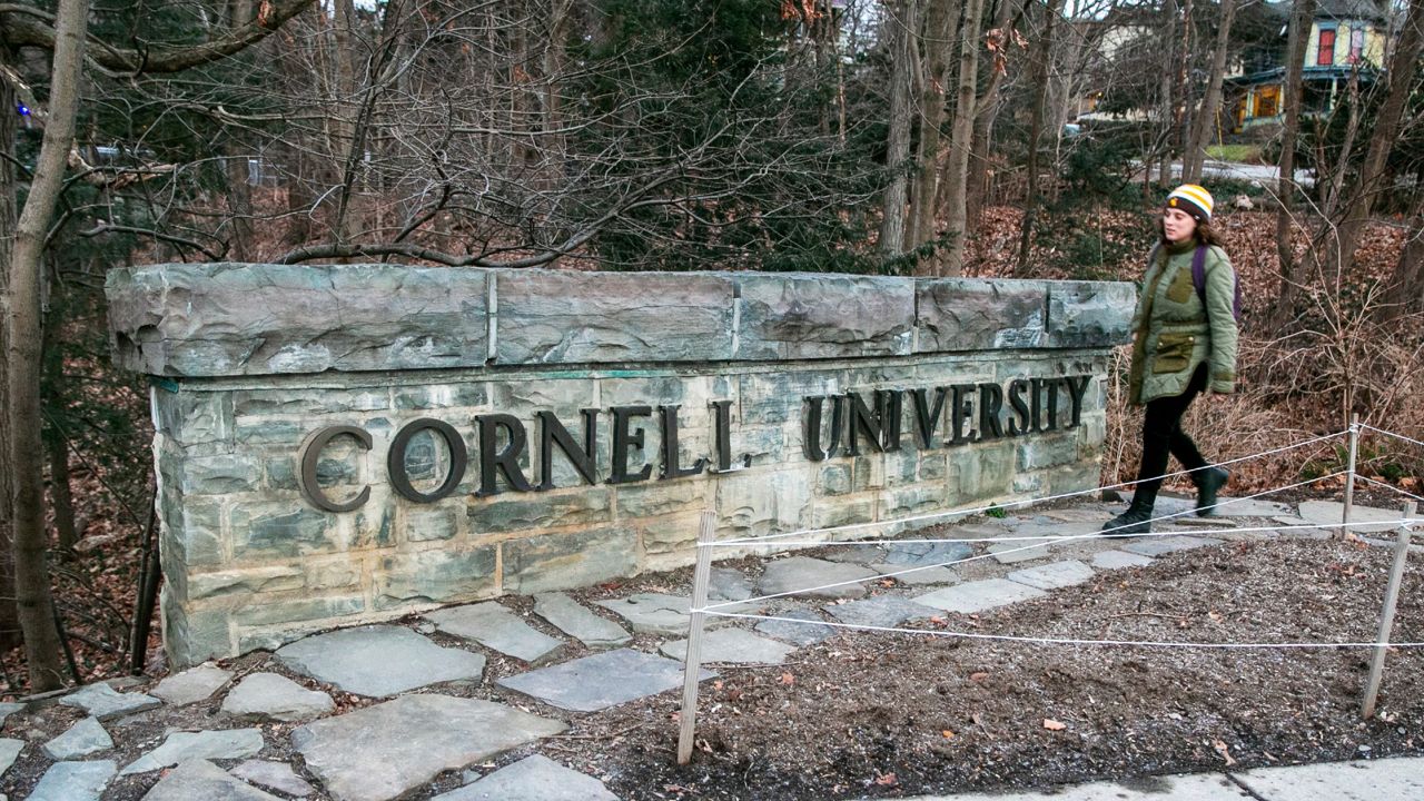 A woman walks by a Cornell University sign on the Ivy League school's campus in Ithaca, New York, on Jan. 14, 2022. (AP Photo/Ted Shaffrey, File)