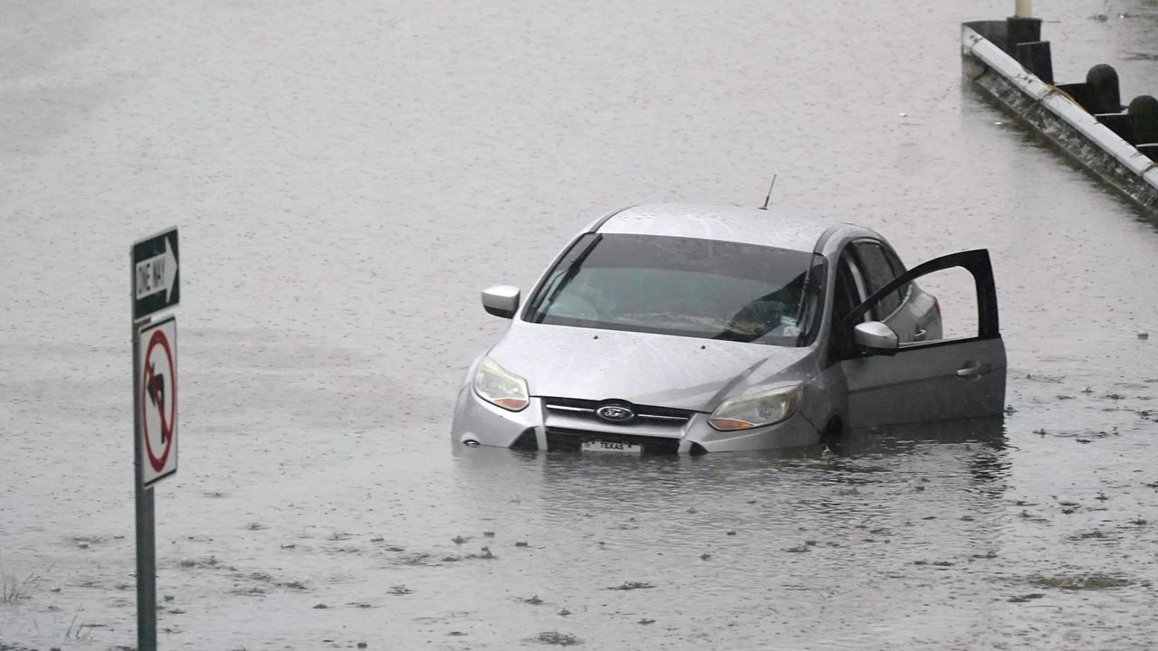 A car sits in flood waters covering a closed highway in Dallas, Monday, Aug. 22, 2022. (AP Photo/LM Otero)
