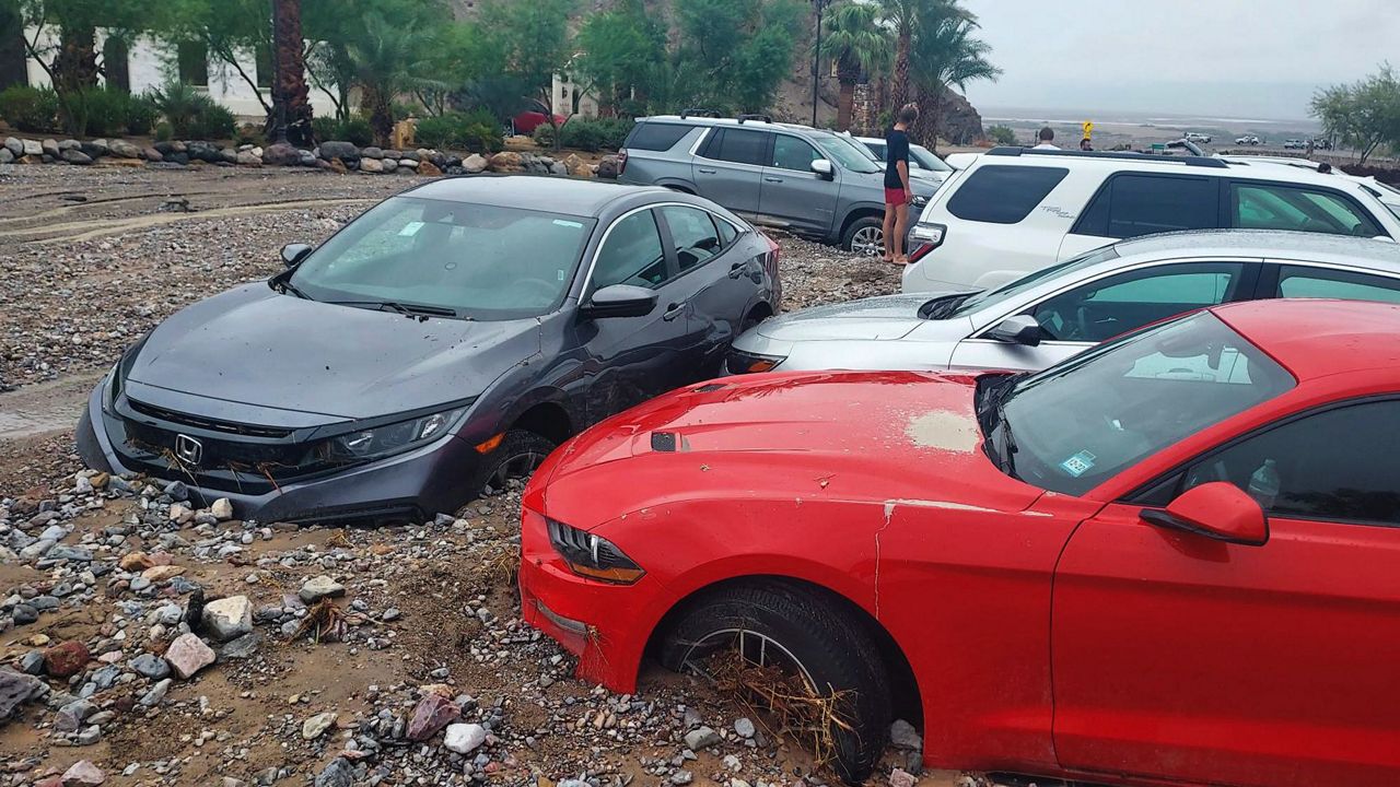 In this photo provided by the National Park Service, cars are stuck in mud and debris from flash flooding at The Inn at Death Valley in Death Valley National Park, Calif., Friday, Aug. 5, 2022. (National Park Service via AP)