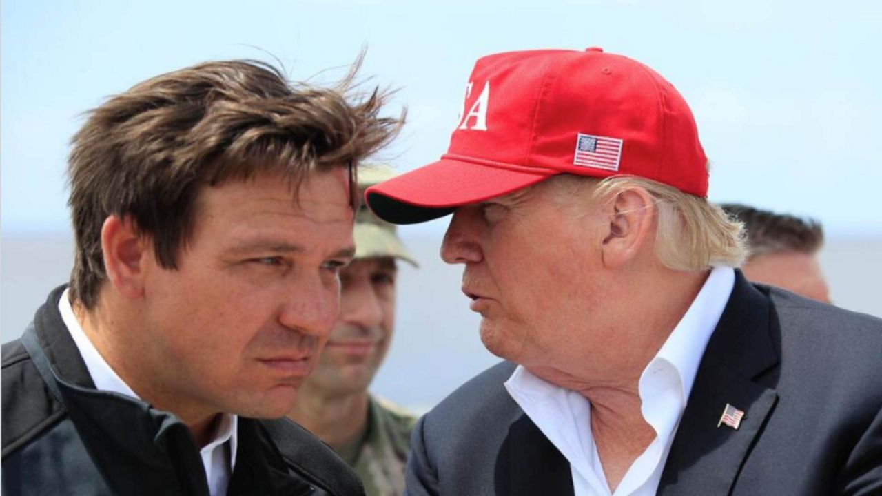 Then-President Donald Trump talks to Florida Gov. Ron DeSantis, left, during a visit to Lake Okeechobee and Herbert Hoover Dike at Canal Point, Fla., March 29, 2019. (AP Photo/Manuel Balce Ceneta, File)