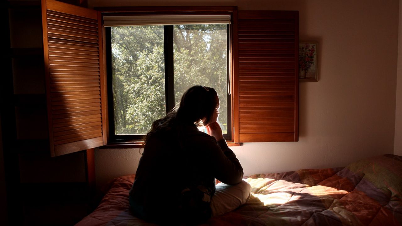 woman sits on a bed