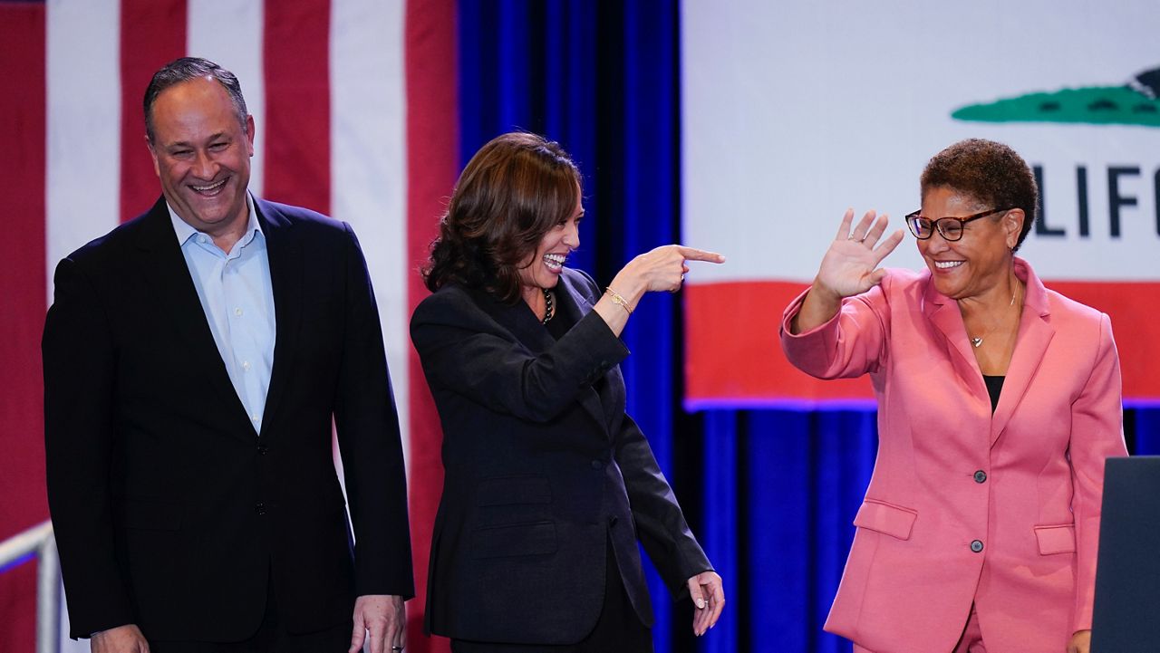 Joined by husband Doug Emhoff, left, Vice President Kamala Harris, center, points to Los Angeles mayoral candidate Rep. Karen Bass, D-Calif., after speaking at a campaign rally in Los Angeles, Monday, Nov. 7, 2022. (AP Photo/Jae C. Hong)