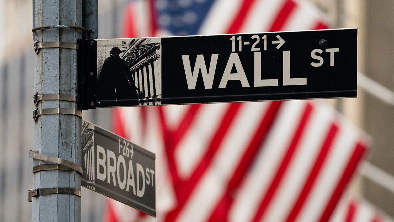 A street sign is seen in front of the New York Stock Exchange in New York, Tuesday, June 14, 2022. AP Photo/Seth Wenig, File)