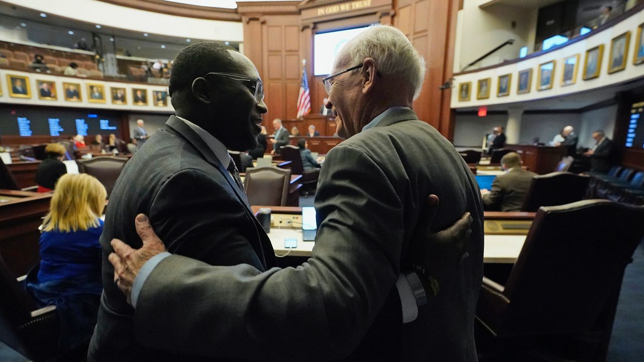 Florida Sen. Dennis Baxley, right, the sponsor of a bill, dubbed by opponents as the "Don't Say Gay" bill, hugs an opponent of the bill, Sen. Shevrin Jones, after the bill passed during a legislative session at the Florida State Capitol, Tuesday, March 8, 2022, in Tallahassee, Fla. (AP Photo/Wilfredo Lee)