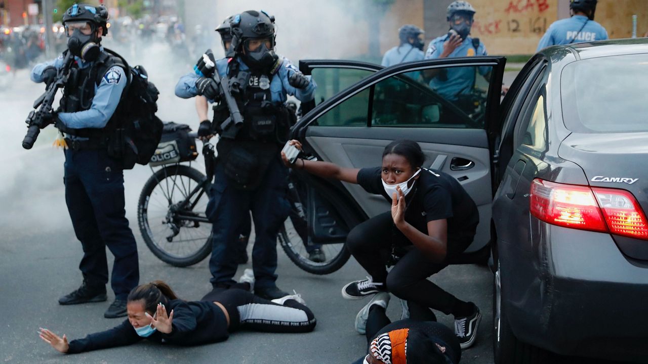 Motorists are ordered to the ground from their vehicle by police on May 31, 2020, during a protest in Minneapolis over the killing of George Floyd. (AP Photo/John Minchillo, File)