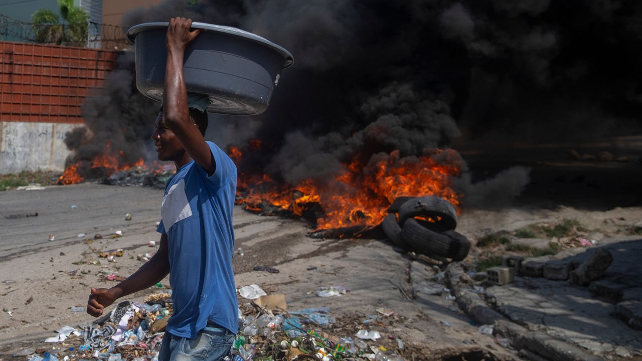 Burning tires block a road, set by protesters in Port-au-Prince, Haiti, Monday, Oct. 18, 2021. Workers angry about the nation’s lack of security went on strike in protest two days after 17 members of a U.S.-based missionary group were abducted by a violent gang. (AP Photo/Joseph Odelyn)