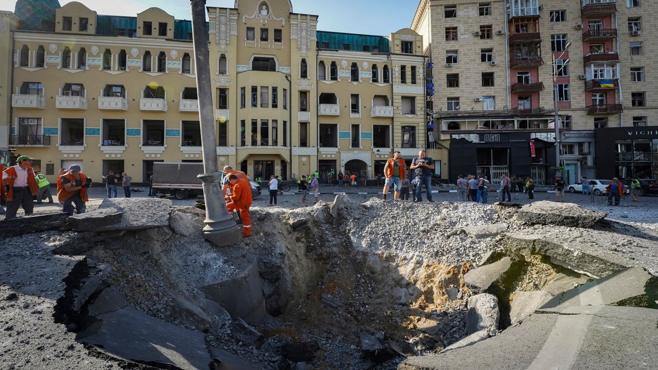 A view of a crater from a night Russian rocket attack, near to damaged buildings in downtown Kharkiv, Ukraine, Saturday, Aug. 27, 2022. (AP Photo/Andrii Marienko)