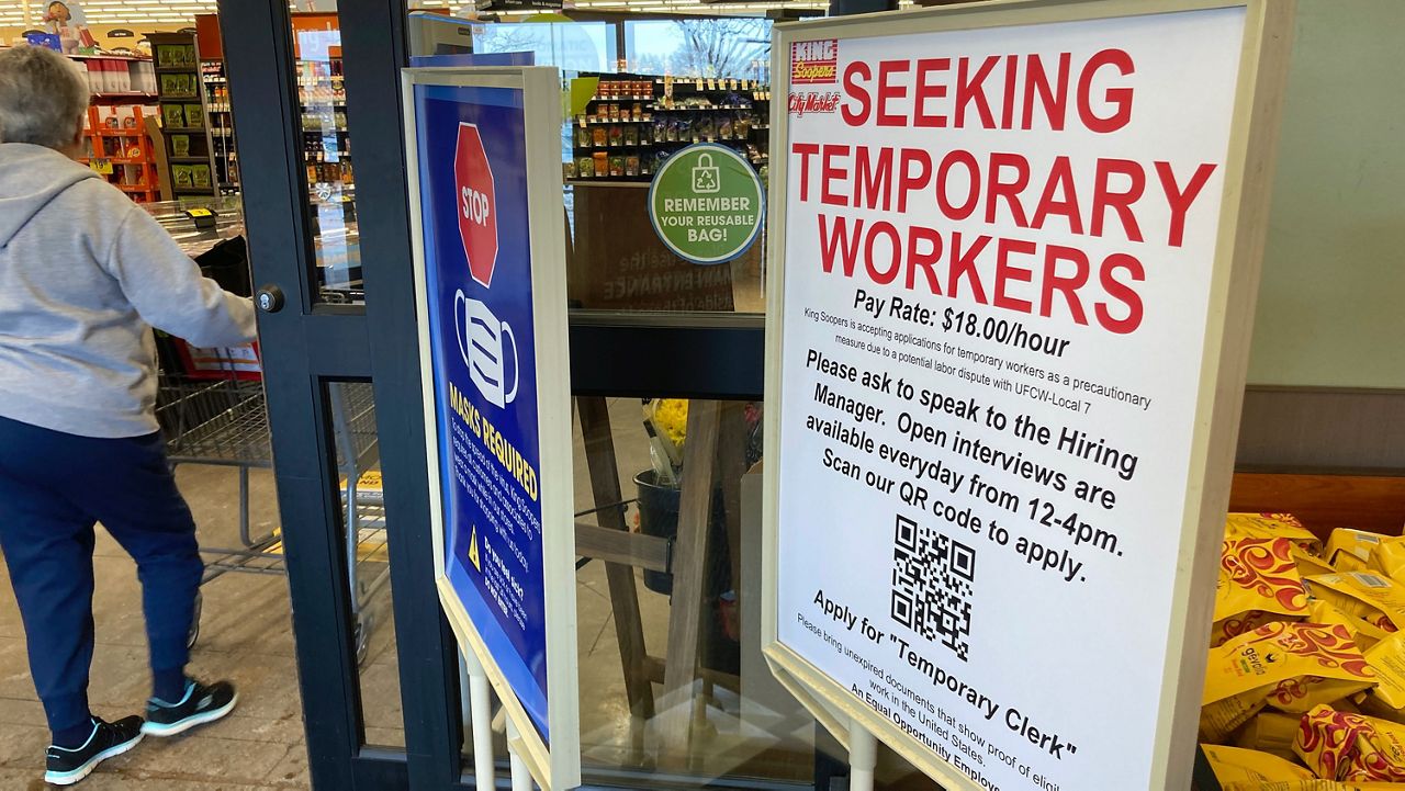 A sign advertising the need for temporary workers stands next to the entrance of a King Soopers grocery store Thursday, Jan. 6, 2022, in southeast Denver. (AP Photo/David ZalubowskI)