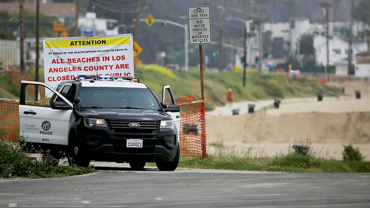 Los Angeles police patrol outside of a closed Los Angeles County Beach