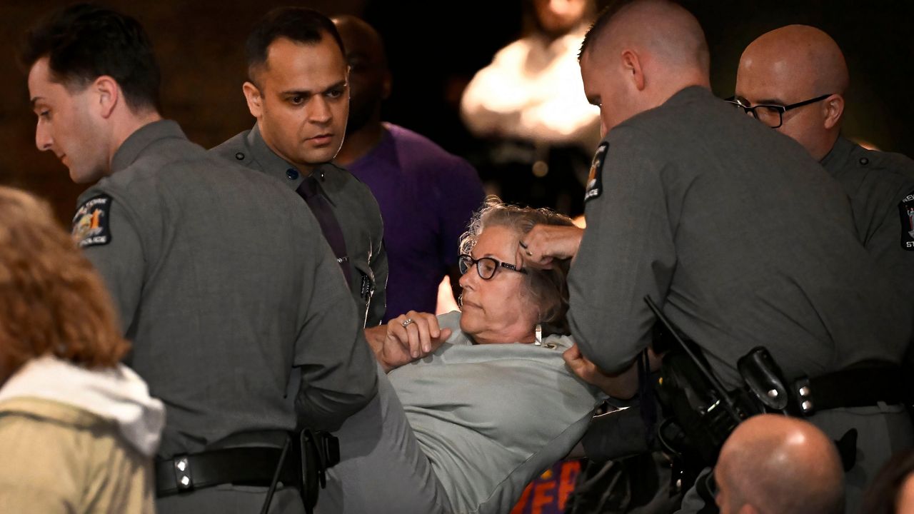A woman is carried out by law enforcement at a town hall held by U.S. Rep. Mike Lawler, R-N.Y., Sunday, May 4, 2025, in Somers, N.Y.