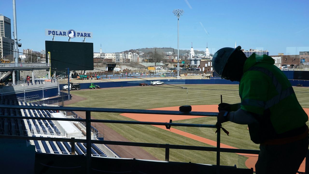 A worker measures a railing at Polar Park, the home of minor league baseball's Worcester Red Sox. (AP Photo/Elise Amendola)