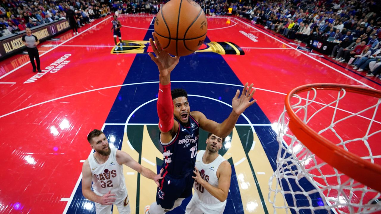 Philadelphia 76ers' Tobias Harris, center, goes up for a shot between Cleveland Cavaliers' Dean Wade, left, and Georges Niang during the first half of an NBA basketball in-season tournament game, Tuesday, Nov. 21, 2023, in Philadelphia. 