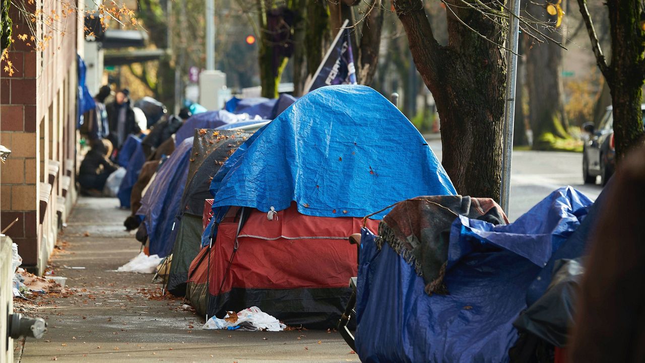 Tents line the sidewalk on SW Clay St in Portland, Ore., Wednesday, Dec. 9, 2020.  (AP Photo/Craig Mitchelldyer, File)