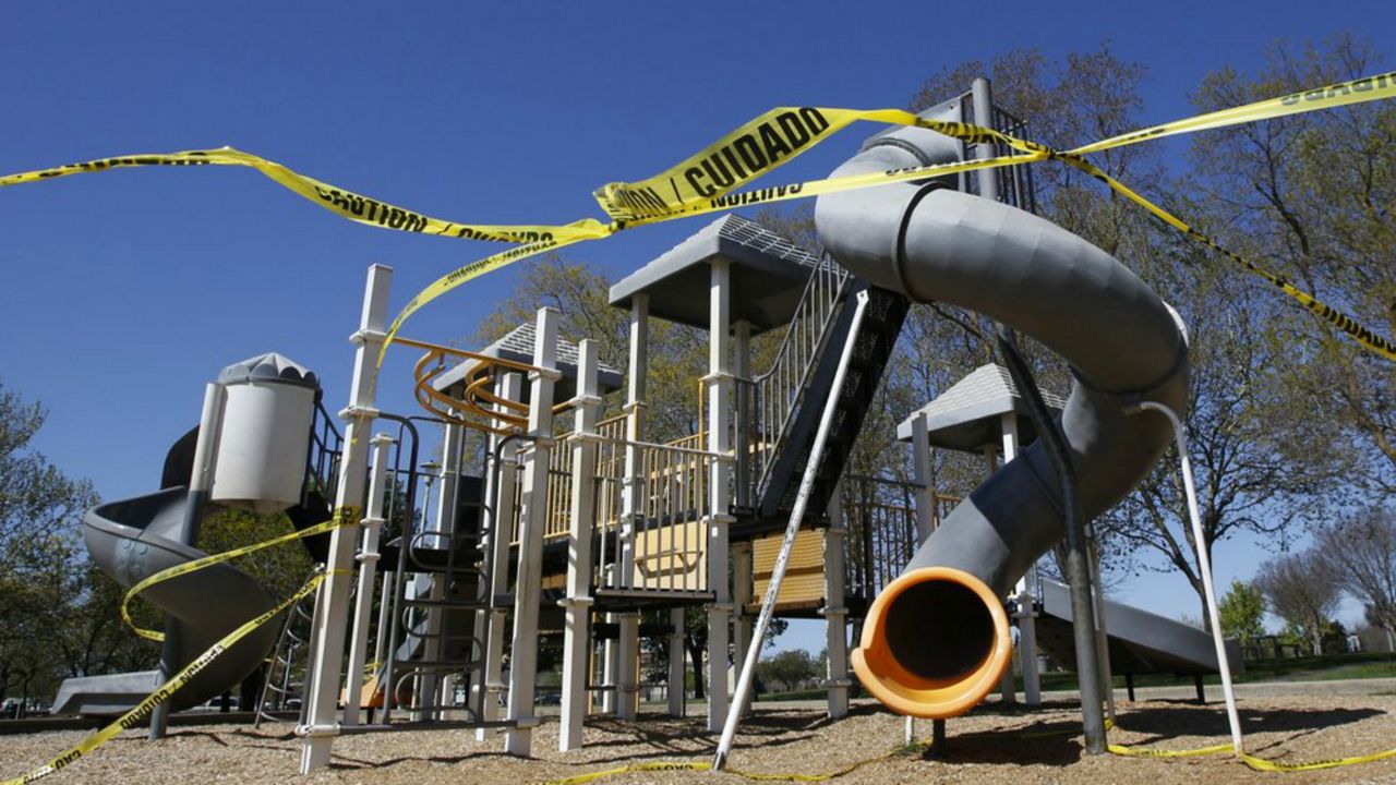 Caution tape surrounds the playground at Country Side Community Park in Elk Grove, Calif., Thursday, April 2, 2020. California has been under a mandatory stay-at-home order for more than a week to help curb the spread of the coronavirus. (AP Photo/Rich Pedroncelli)