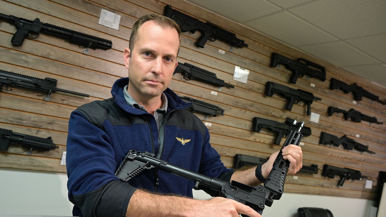 Adrian Kellgren, director of industrial production of KelTec, holds a 9mm SUB2000 rifle, similar to ones being shipped to Ukraine. (AP Photo/Phelan M. Ebenhack)