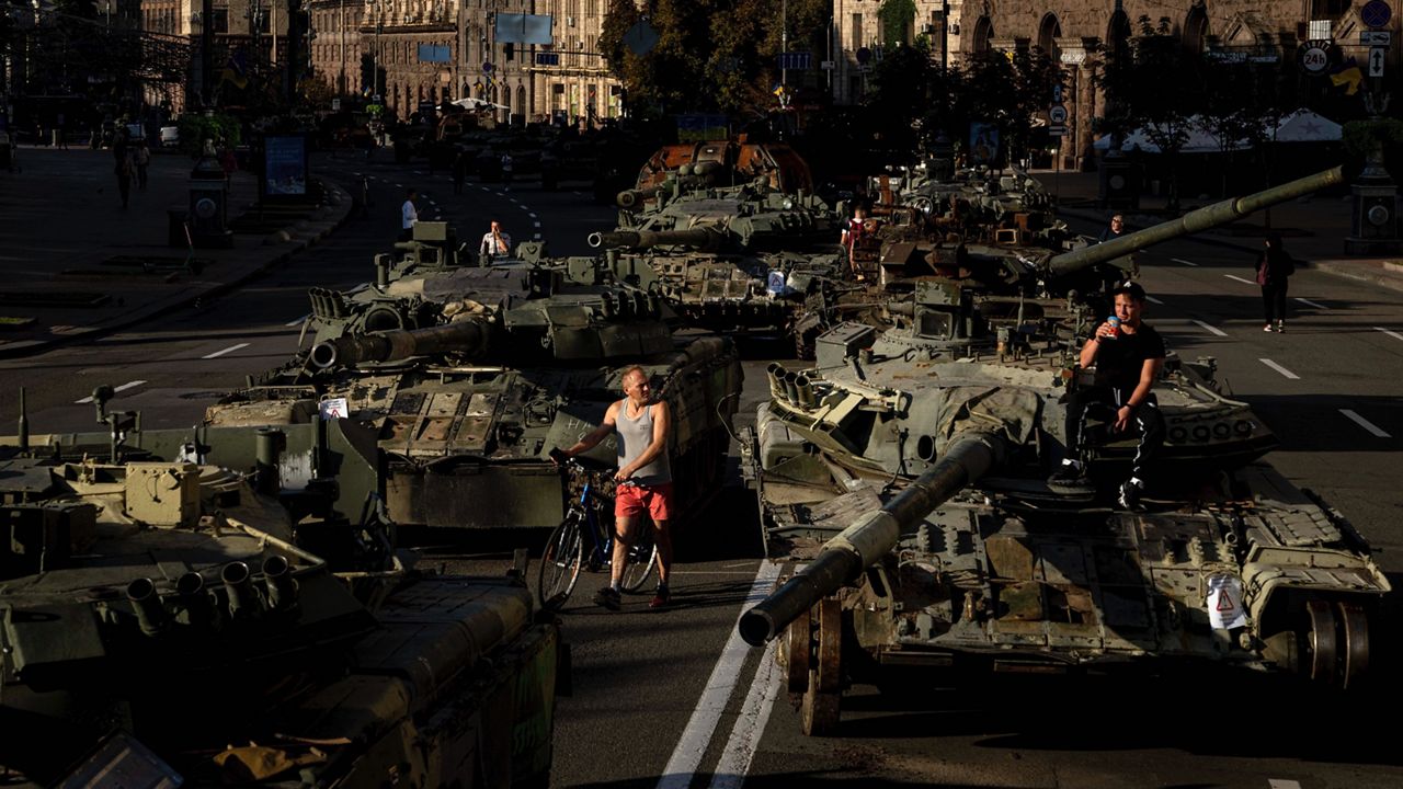 People walk around destroyed Russian military vehicles installed in downtown Kyiv, Ukraine, Wednesday, Aug. 24, 2022. Kyiv authorities have banned mass gatherings in the capital through Thursday for fear of Russian missile attacks. Independence Day, like the six-month mark in the war, falls on Wednesday. (AP Photo/Evgeniy Maloletka)