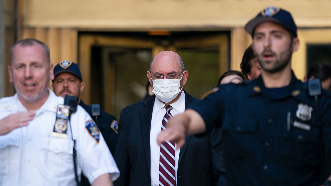 Law enforcement personnel escort the Trump Organization's former Chief Financial Officer Allen Weisselberg, center, as he departs court, Friday, Aug. 12, 2022, in New York. (AP Photo/John Minchillo, File)