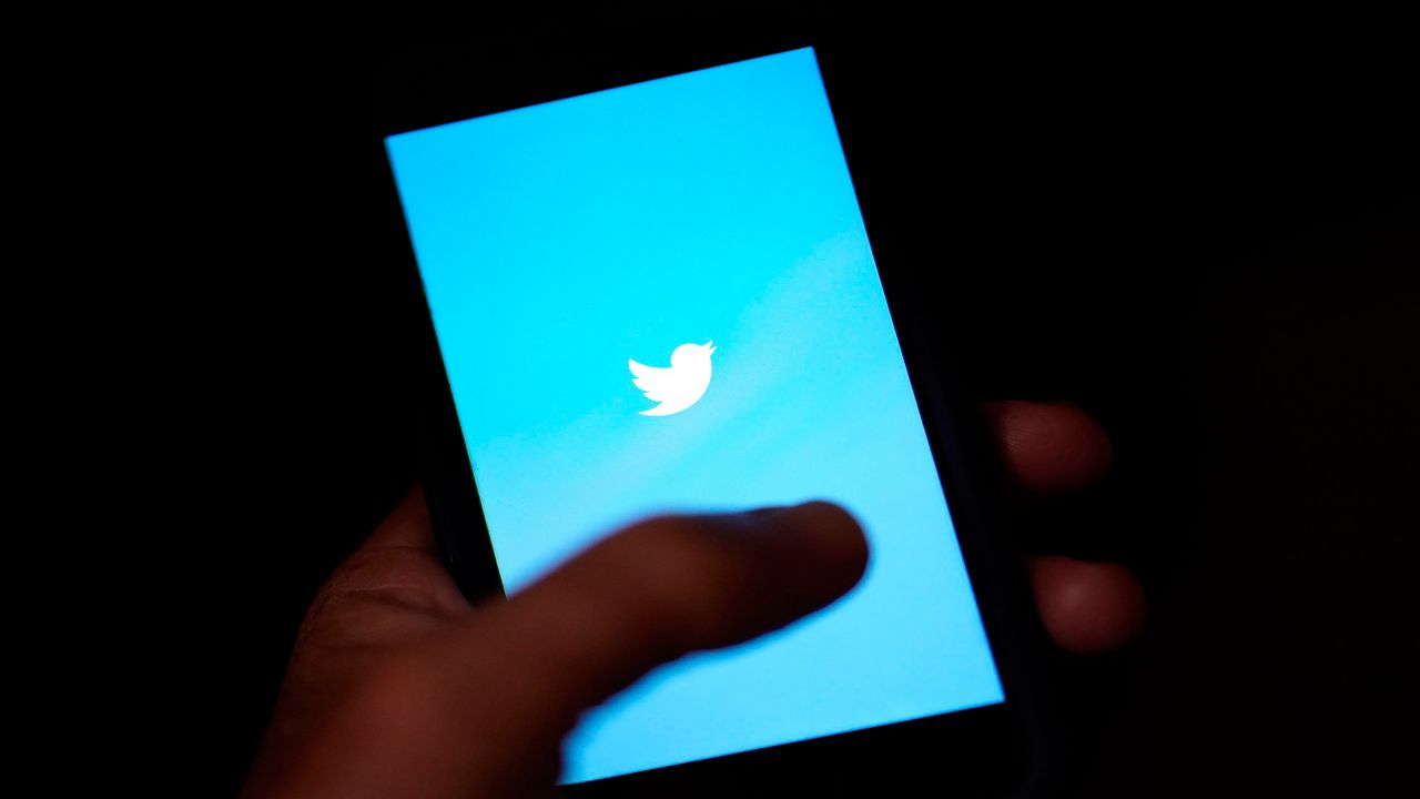 A person holds a phone with the Twitter app open. (AP)