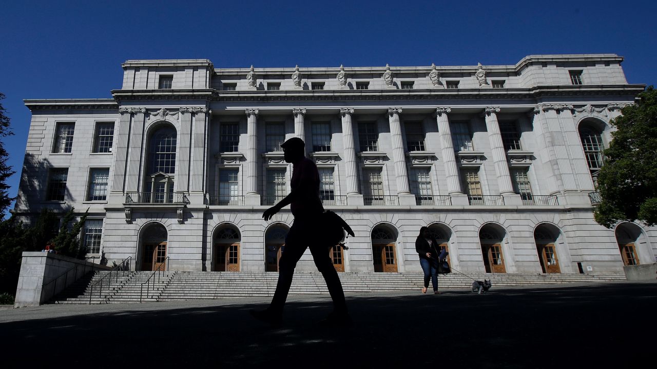 People walk in front of Wheeler Hall on the University of California campus in Berkeley, Calif., on March 11, 2020. (AP Photo/Jeff Chiu, File)