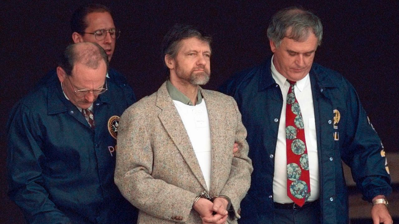 Theodore Kaczynski looks around as U.S. Marshals prepare to take him down the steps at the federal courthouse to a waiting vehicle on June 21, 1996 in Helena.