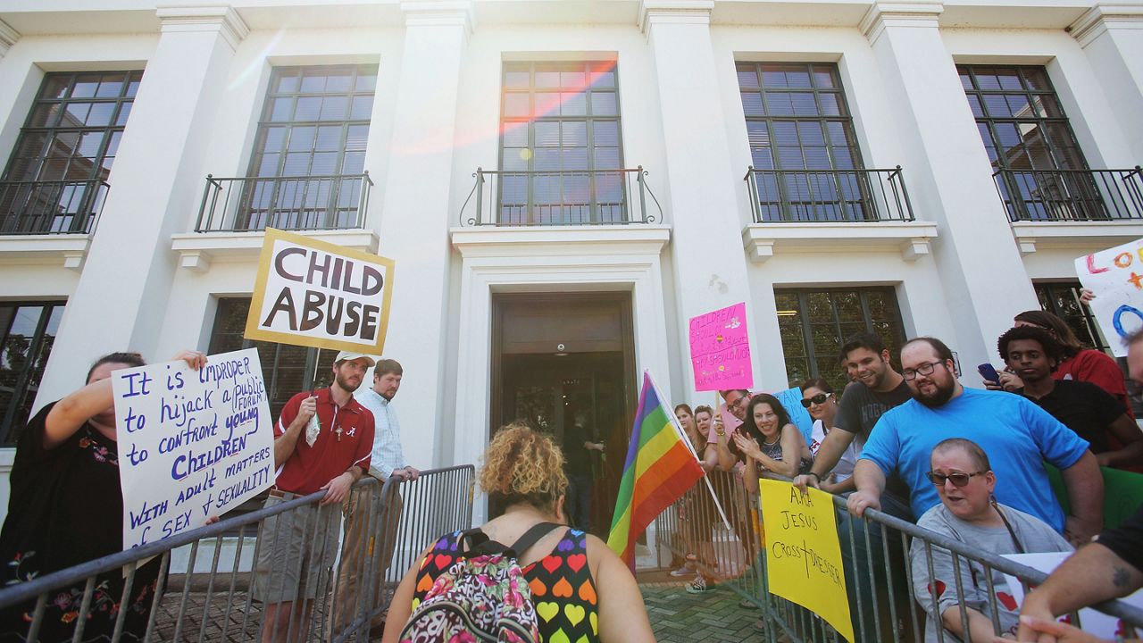 Protesters watch as a parent walks their child past counter protesters into the Mobile Public Library for Drag Queen Story Hour in Mobile, Ala. on Sept. 8, 2018. The event, sponsored by LGBT group Rainbow Mobile, involves local drag queen performers reading to children. (AP Photo/Dan Anderson, File)