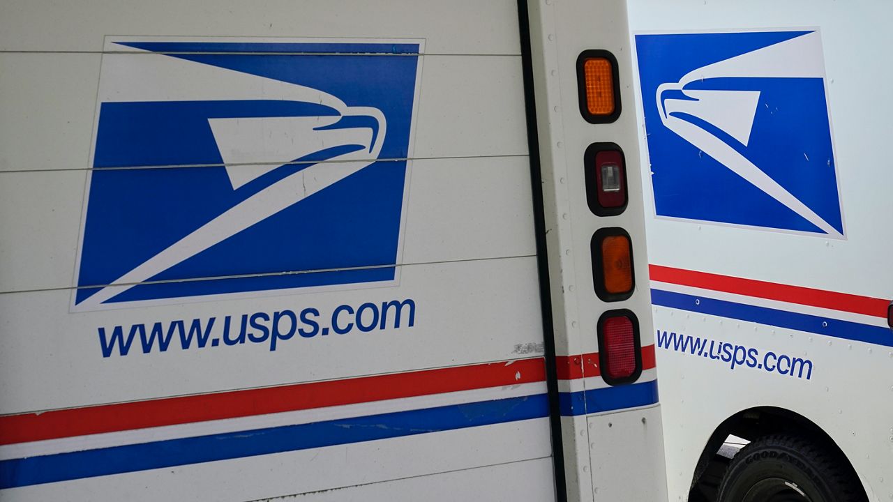 In this Aug. 18, 2020, file photo, mail delivery vehicles are parked outside a post office in Boys Town, Neb. (AP Photo/Nati Harnik, File)