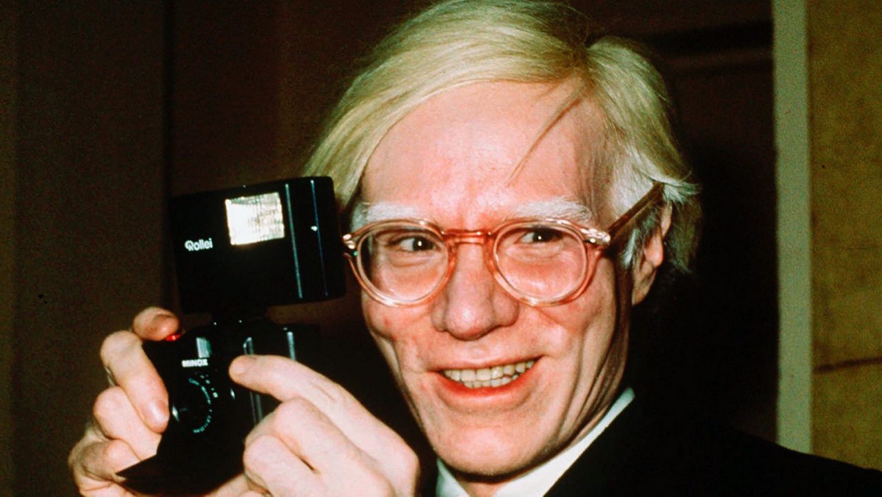 FILE - In this 1976 file photo, pop artist Andy Warhol smiles in New York. The Supreme Court has agreed to review a copyright dispute involving works of art by Warhol and a photographer who took an image of the musician Prince that the works are based on. (AP Photo/Richard Drew, File)
