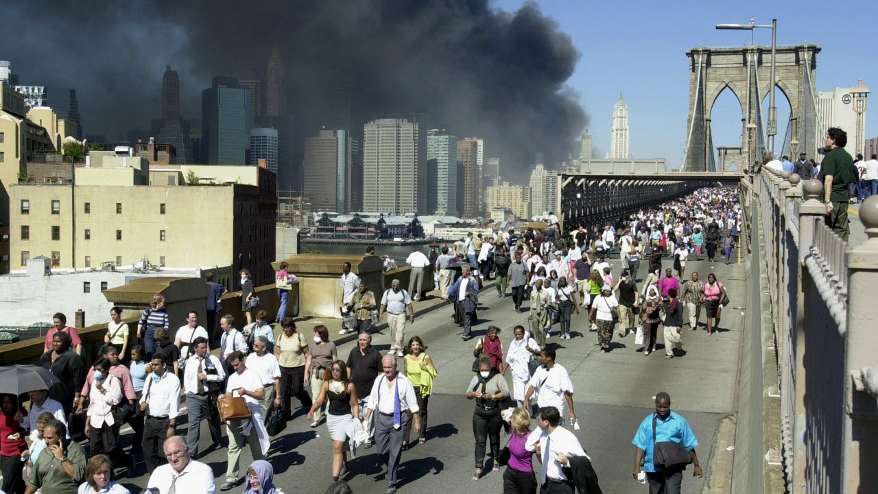 People walked over the Brooklyn Bridge to leave Manhattan following the collapse of the World Trade Center towers, September 11, 2001. (AP Photo/Mark Lennihan)