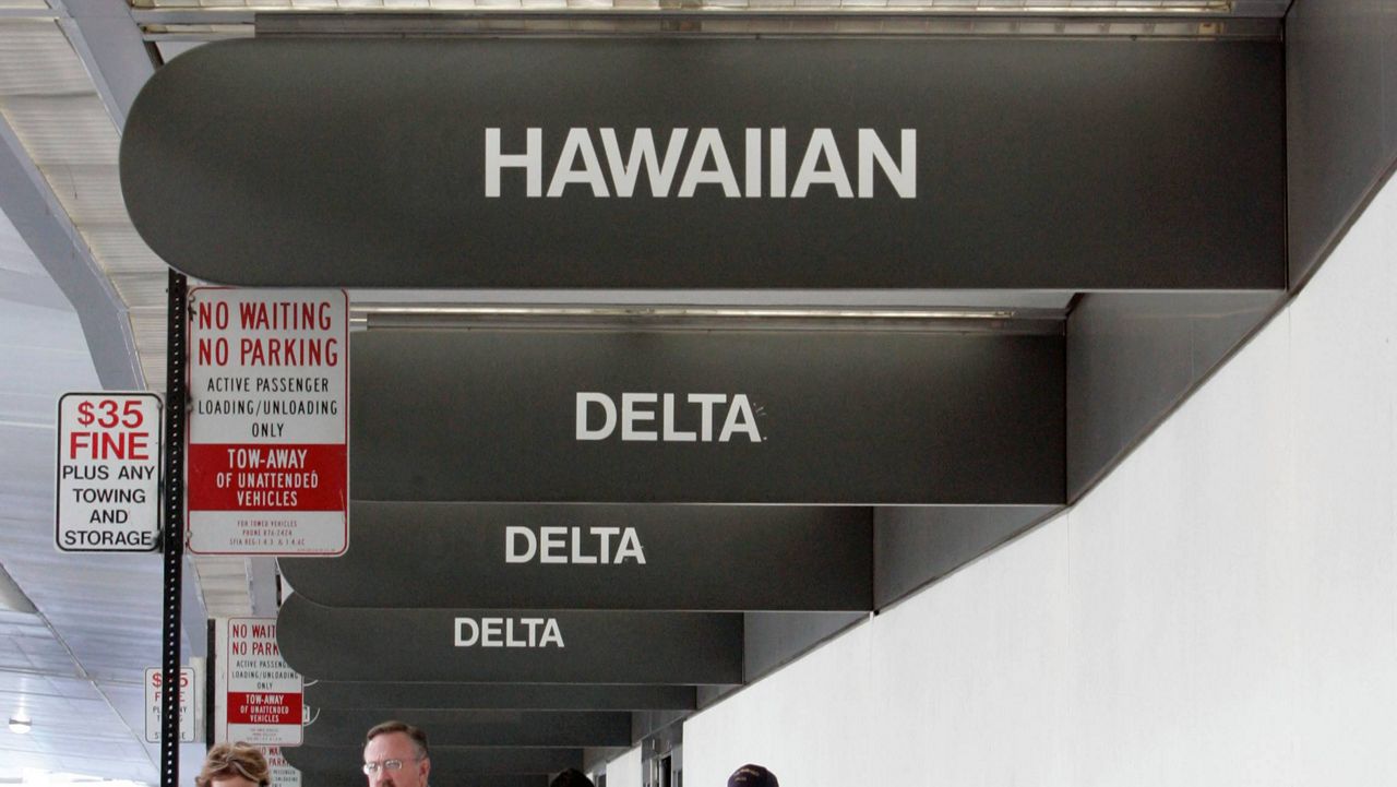 Hawaiian and Delta Airlines signs are posted at San Francisco International Airport. (AP Photo/Paul Sakuma, file)