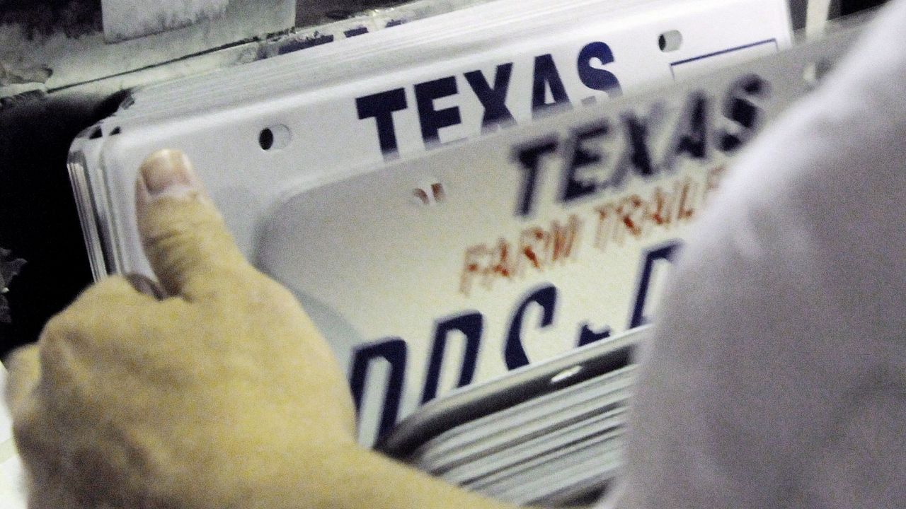 In this March 31, 2009 photo, an inmate inspects a stack of new Texas license plates at the Wynne Farm Unit of the Texas Department of Criminal Justice in Huntsville, Texas. (AP Photo/Pat Sullivan)