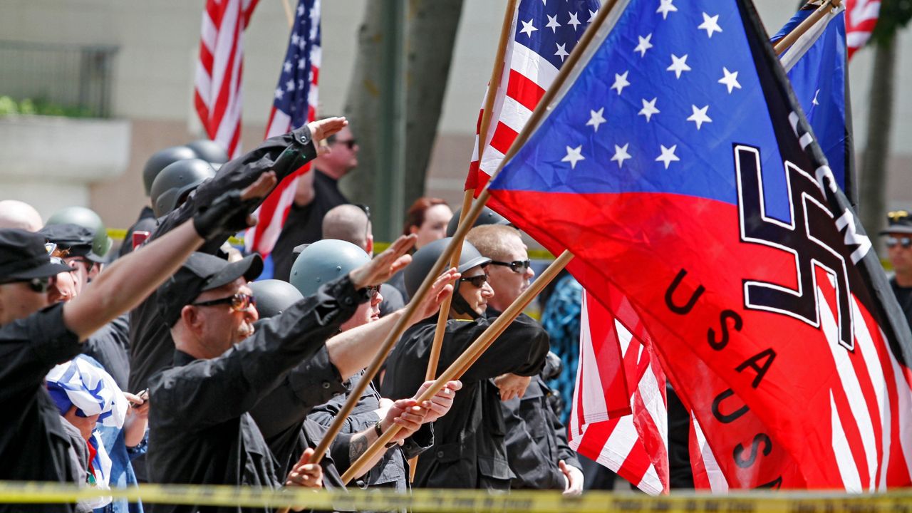 A white supremacist group salutes American flags and banners with swastikas at Los Angeles City Hall on Saturday, April 17, 2010. (AP Photo/Richard Vogel)